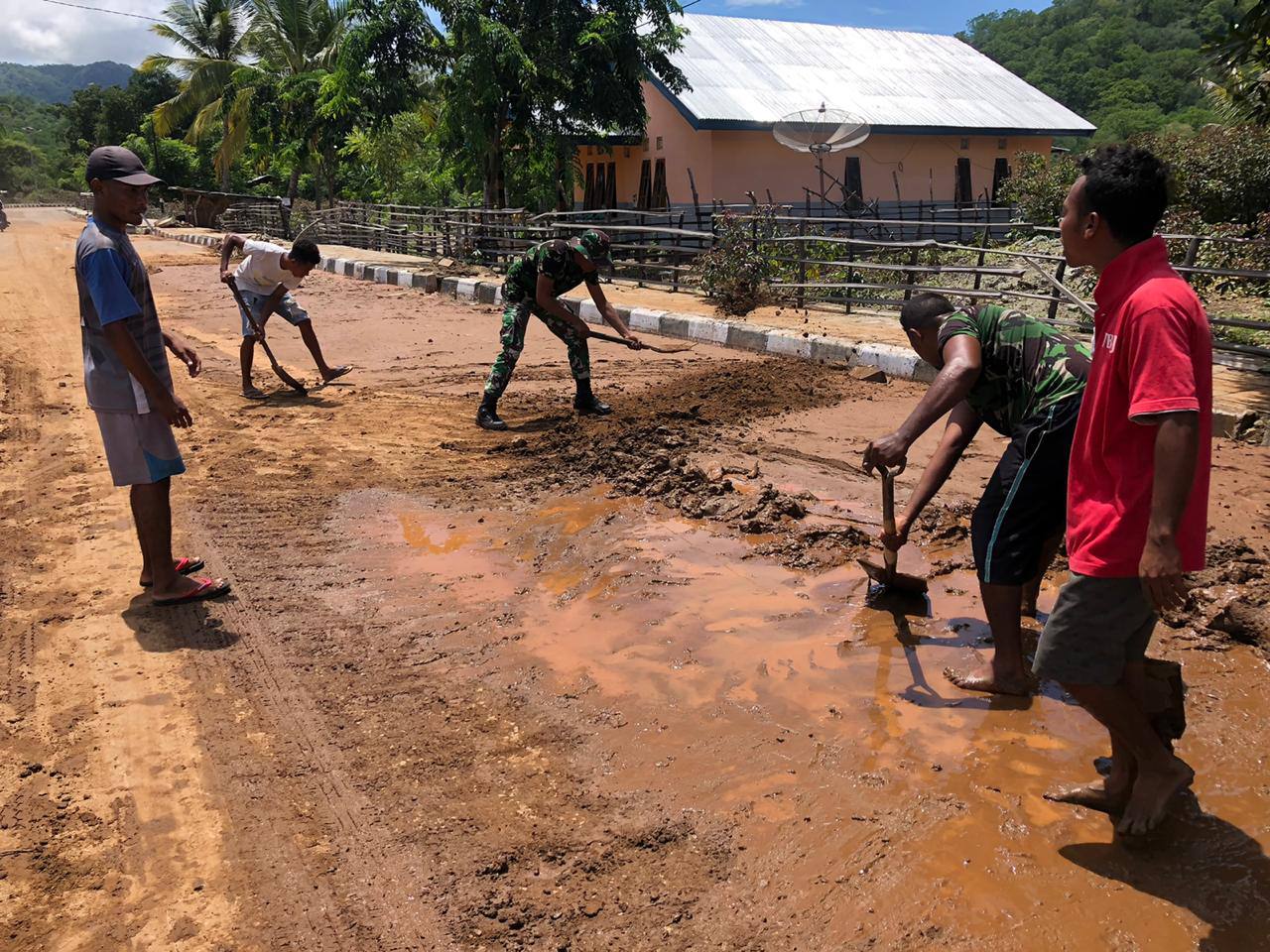 Pasca Banjir, Satgas Yonif RK 744/SYB Bersama Warga Bersihkan Lumpur di Jalan Raya