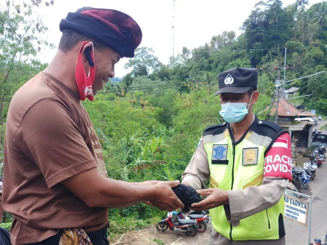 Terapkan Prokes Bhabinkamtibmas Bagikan Masker