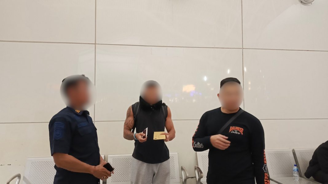 Warga Negara Prancis berinisial L.R (tengah) saat dideportasi mellaui Bandara Ngurah Rai Bali, Kamis (27/08/2027). Foto: Dok Imigrasi Denpasar.