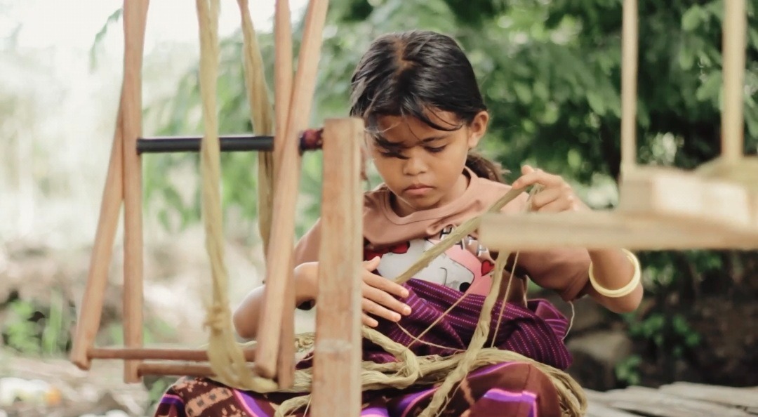 Seorang anak perempuan Adonara yang sedang belajar menenun di Rumah Tenun Milenila, Desa Boleng, Adonara, NTT. Foto: Istimewa